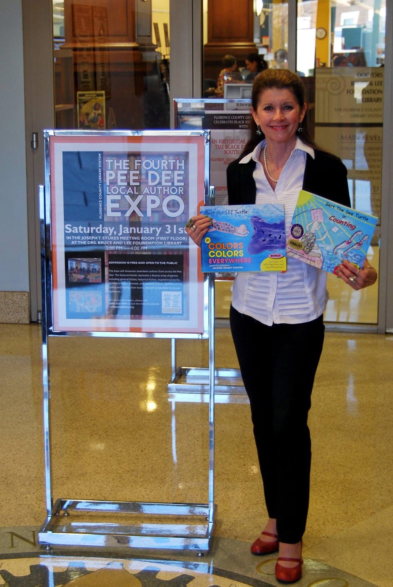 Maxine Moody Poston holding Gert the SEE Turtle books at a local author expo